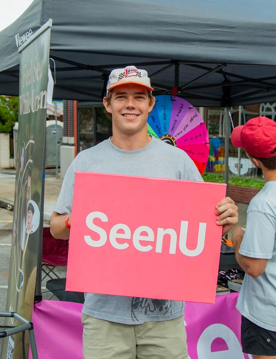 Guy holding a SeenU placard